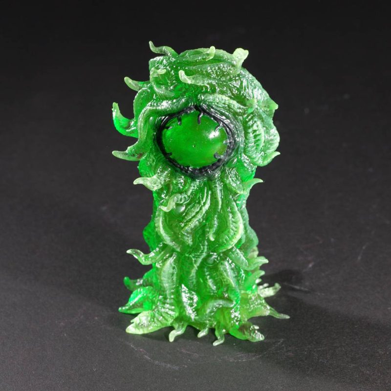 Bright green idol holding a glossy green orb
